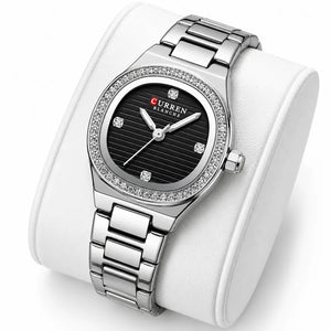 Montre femme argentée à cadran noir Minoran 9101 sur coussin blanc