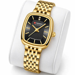 Montre femme dorée Minoran 9093 à cadran noir présentée sur un coussin blanc
