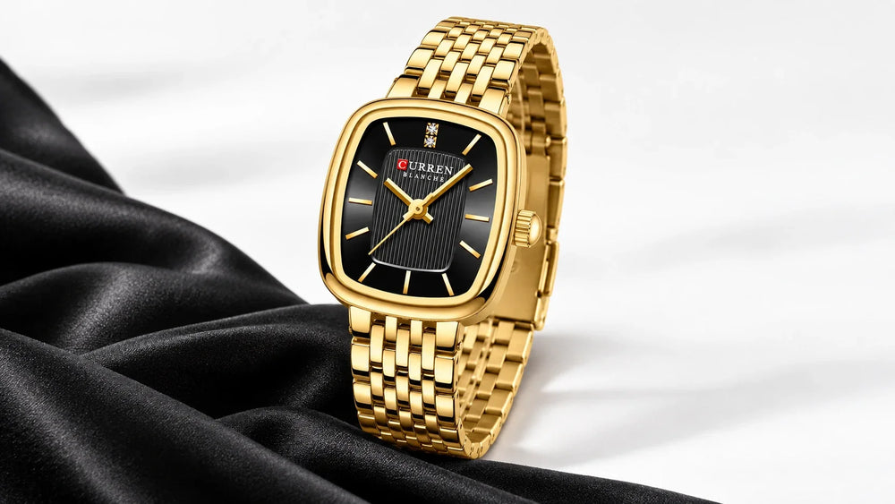 Montre femme Minoran 9093 dorée à cadran noir rectangulaire, présentée sur un fond blanc avec une étoffe noire.