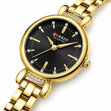 Montre Minoran 9098 dorée à cadran noir en zoom diagonal, avec index en bâtons et détails brillants
