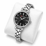 Montre femme argentée à cadran noir Minoran 9098 présentée sur un coussin blanc