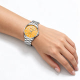 Montre femme argentée Minoran 9090 à cadran orange portée au poignet