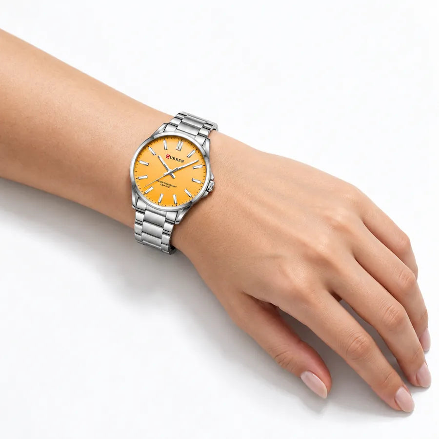 Montre femme argentée Minoran 9090 à cadran orange portée au poignet