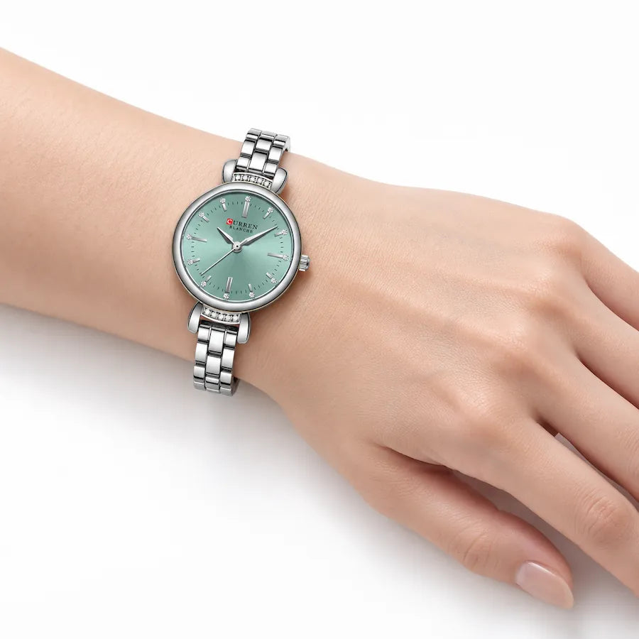 Montre ronde argentée Minoran 9098 portée au poignet, cadran vert menthe visible