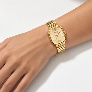 Montre femme dorée Minoran 9093 à cadran doré portée au poignet d’une femme