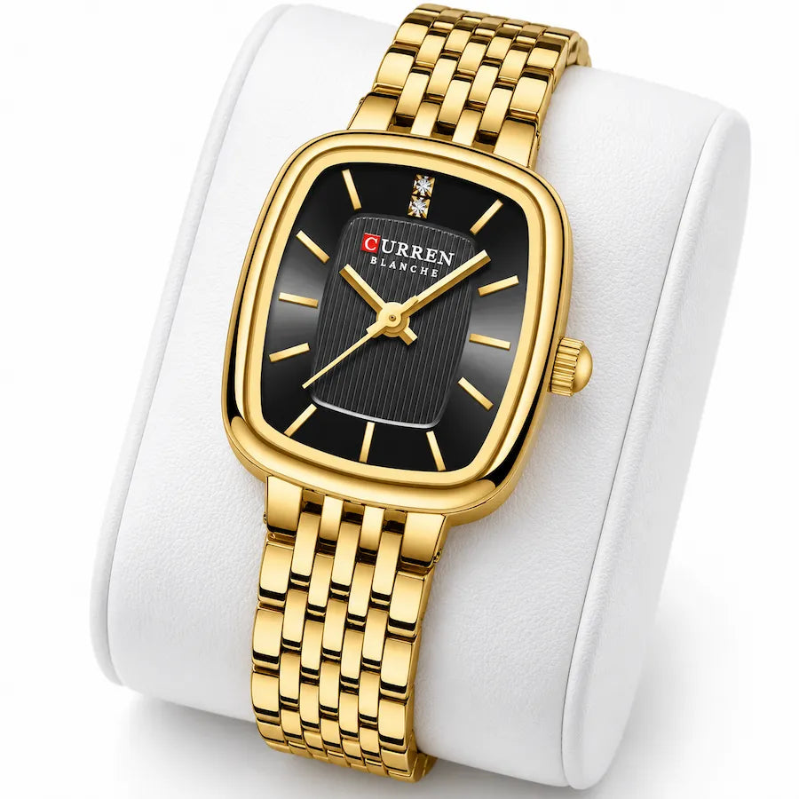 Montre femme dorée Minoran 9093 à cadran noir présentée sur un coussin blanc