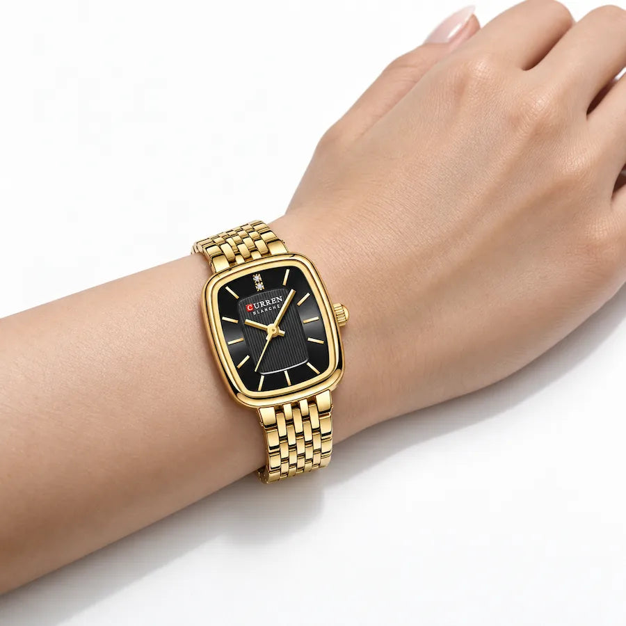 Montre femme dorée Minoran 9093 à cadran noir portée au poignet d’une femme