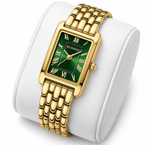 Montre femme dorée à cadran vert Minoran 9115 présentée sur un coussin blanc