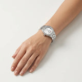 Montre Minoran 9101 à cadran argenté portée au poignet, main sur une table