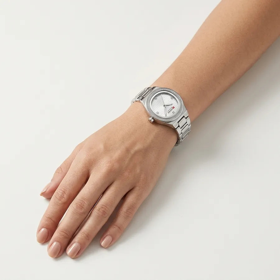 Montre Minoran 9101 à cadran argenté portée au poignet, main sur une table