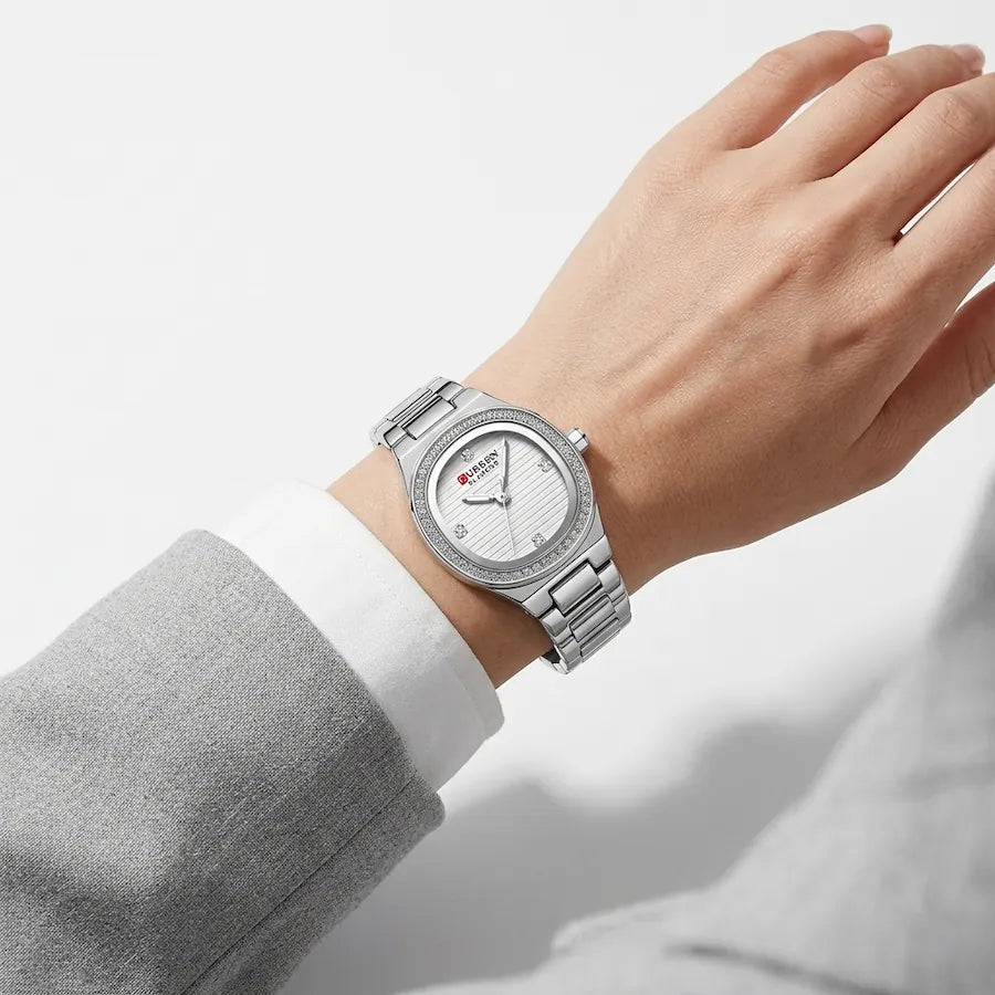 Montre Minoran 9101 à cadran argenté portée au poignet avec un vêtement gris