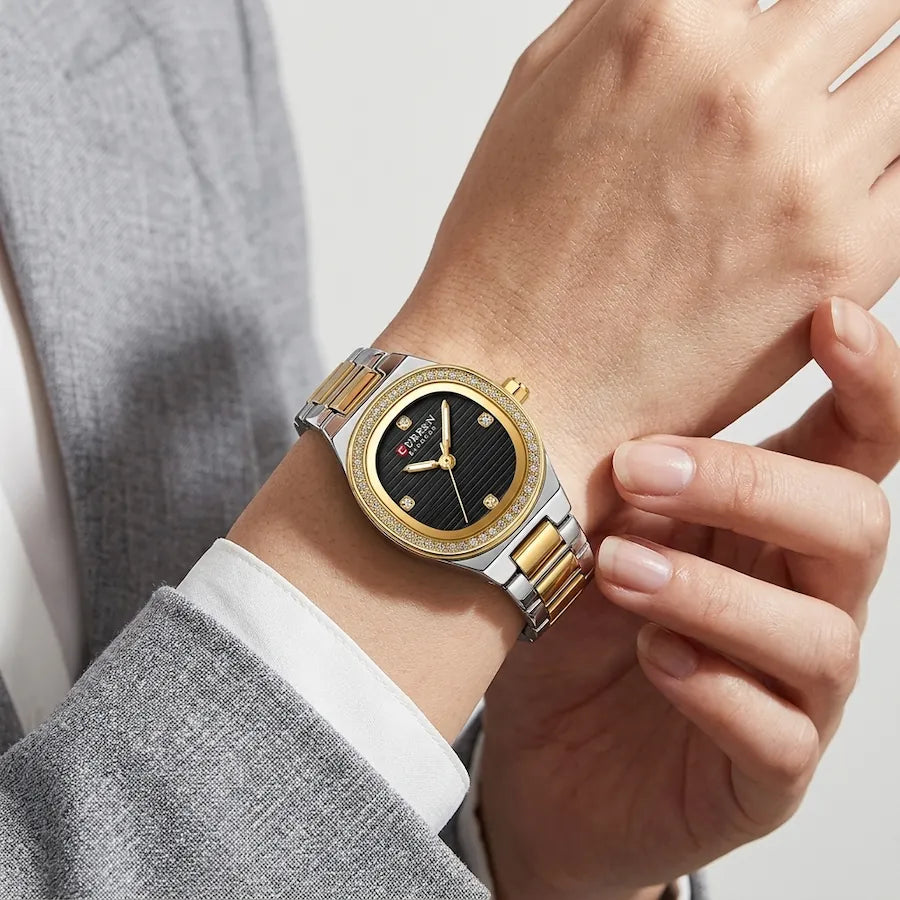 Montre Minoran 9101 à cadran noir portée au poignet avec un vêtement gris