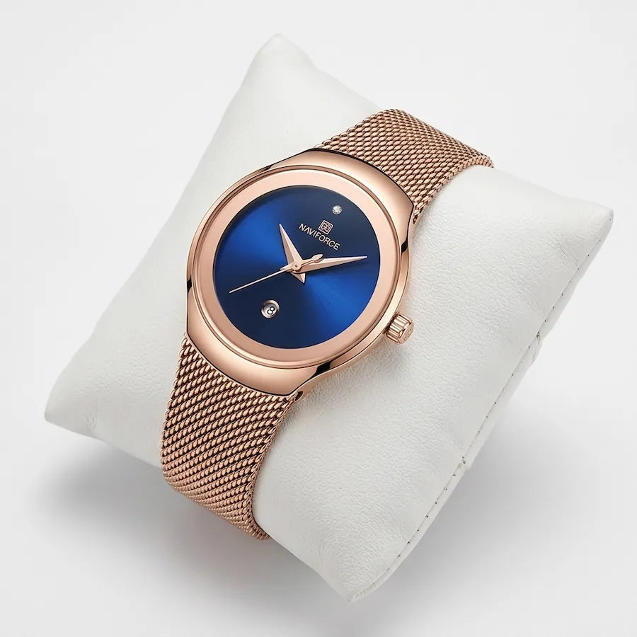 Montre femme or rose Minoran NF5004 à cadran bleu présentée sur un coussin blanc