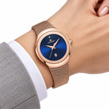 Minoran NF5004 or rose à cadran bleu au poignet avec une veste grise