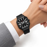 Montre Minoran NF6108, bracelet silicone noir, cadran noir, portée au poignet avec une veste grise
