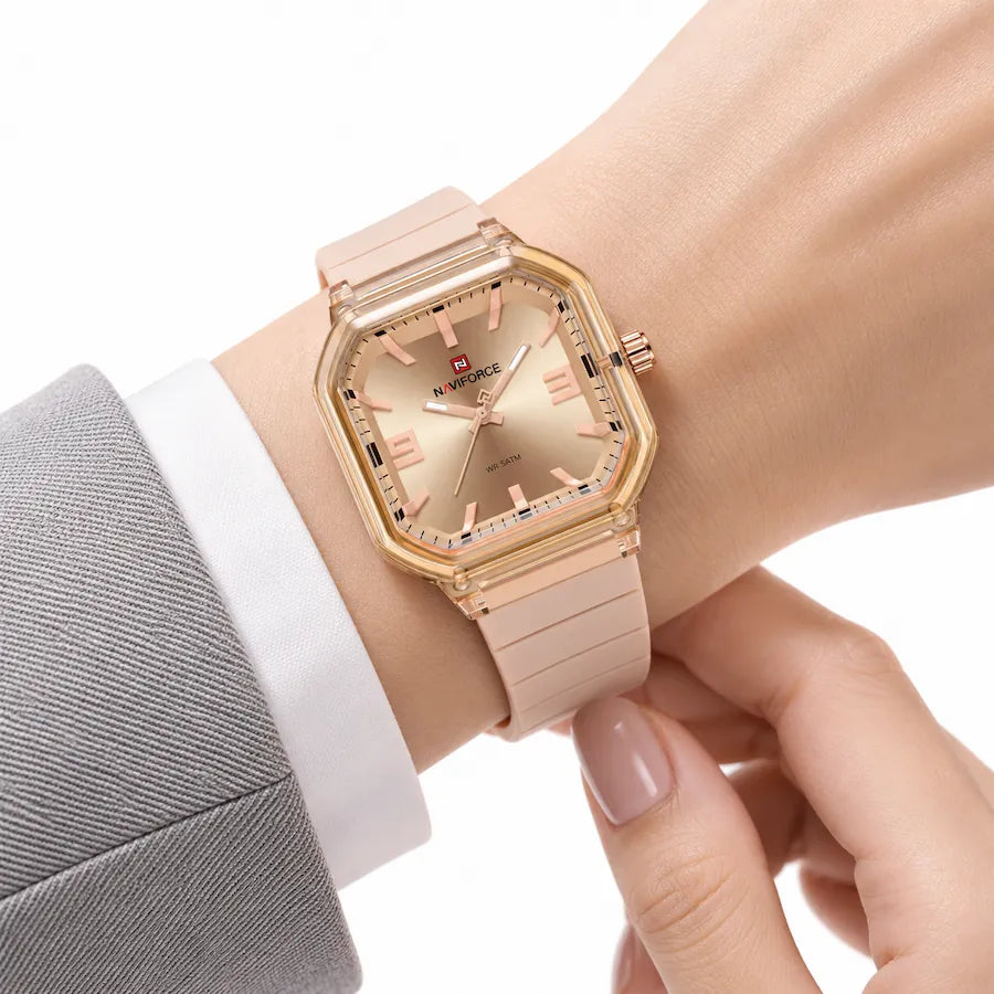 Montre Minoran NF6108, bracelet silicone nude, cadran doré, portée au poignet avec une veste grise