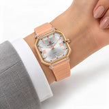 Montre Minoran NF6108, bracelet silicone pêche, cadran argenté, portée au poignet avec une veste grise