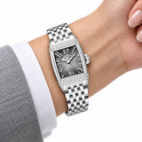 Montre Minoran PD-1737 argentée à cadran gris au poignet avec un blazer