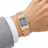 Montre Minoran PD-1737 dorée à cadran gris au poignet avec un blazer