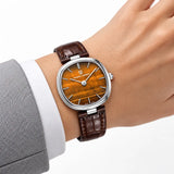Montre Minoran PD-1825 marron en cuir au poignet avec un blazer