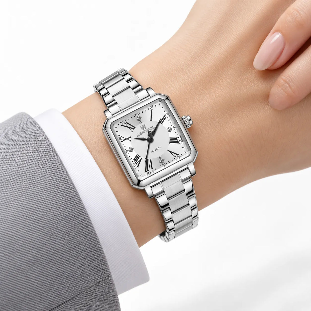 Montre Minoran NF5065 argentée à cadran blanc portée au poignet au bord d’une manche grise